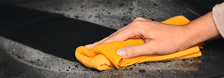 Person cleaning oven with cloth