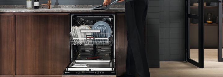A women loading dishes in her Electrolux dishwasher