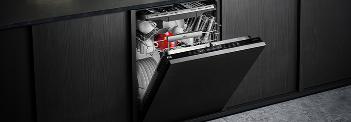 A slightly open AEG dishwasher filled with clean dishes